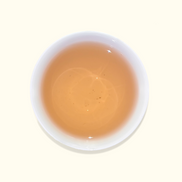 White ceramic cup filled with a light brown liquid on a white background